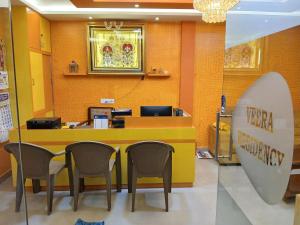 a hotel lobby with a counter with chairs and a surfboard at Veera Residency Gingee in Gingee