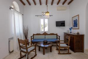 a living room with a couch and chairs and a table at Villa Marble Tinos in Agios Fokas