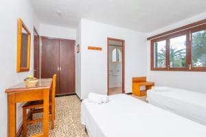 a bedroom with two beds and a desk and a table at La Ceiba in Santanyi +6 photos