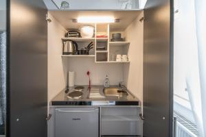 a small kitchen with a sink and a stove at Ruben's Apartments in Stuttgart