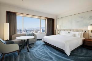 a hotel room with a bed and a table and a window at The Westin Osaka in Osaka