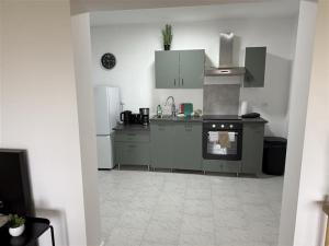 a kitchen with white cabinets and an oven at Work & Stay in Burscheid in Burscheid