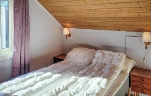 a bed in a bedroom with a wooden ceiling at 1 Bedroom Amazing Apartment In Stord in Stord