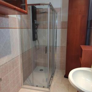 a glass shower in a bathroom with a sink at Alma House - Affitti Brevi Italia in Porto Torres