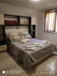 a bedroom with a large bed with two towels on it at Alma House - Affitti Brevi Italia in Porto Torres
