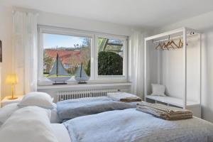 a bedroom with two beds and a window with a sailboat in it at Ferienwohnung Am Kurpark in Germete