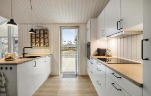 una cucina con mobili bianchi e una grande finestra di 4 Bedroom Lovely Home In Liseleje a Liseleje Altre 13 foto