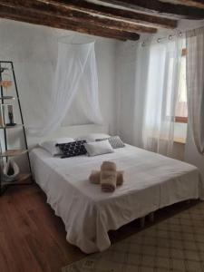 una camera da letto con un letto bianco con asciugamani sopra di Agreable maison anduzienne au coeur du village ad Anduze