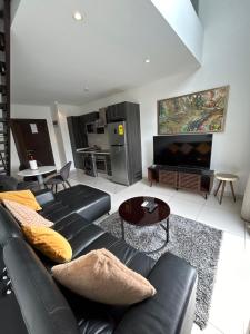 a living room with a black couch and a tv at Cozy Abode by Embassy Gardens in Accra