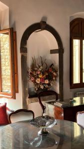 une salle à manger avec une table et une couronne sur le mur dans l'établissement Ponte Vecchio - Appartamento Oltrarno Ruby, à Florence