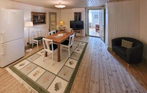 a kitchen and living room with a table and a refrigerator at Lovely Apartment In Åseda With Wifi in Åseda