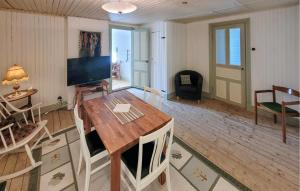 a living room with a table and a television at Lovely Apartment In Åseda With Wifi in Åseda +8 photos
