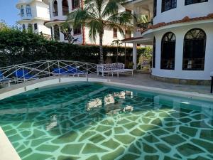 a swimming pool in front of a house at J and R Villa, Watamu in Watamu