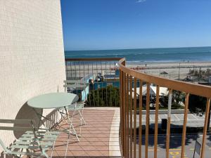 a balcony with a table and chairs and the beach at La Corte Dei Mari Acquamarina in Cesenatico