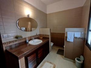 a bathroom with a sink and a mirror and a toilet at J and R Villa, Watamu in Watamu