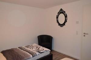 ein Schlafzimmer mit einem Stuhl und einem Spiegel an der Wand in der Unterkunft Loft Apartment Horrem in Kerpen