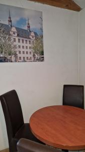 a table and chairs in a room with a picture on the wall at Wohnung im Landhausstil für Monteure in Budenheim in Budenheim