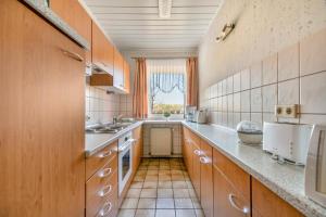 a kitchen with wooden cabinets and a large window at Ferienwohnung Sawade Schafstedt in Schafstedt