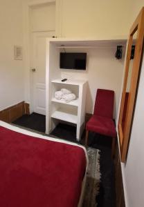 Un dormitorio con una cama roja y una silla roja. en Residencial do Sul, en Lisboa