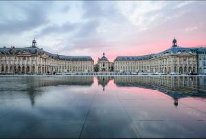 Saint-Médard-de-GuizièresにあるChambre zenの水面に映る大きな建物