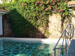 a house with a swimming pool with pink flowers at J and R Villa, Watamu in Watamu