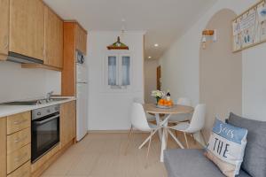 a kitchen with a table and a small kitchen with a table and chairs at Horizonte beachfront apartment in Ifach +14 photos