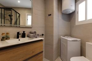 a bathroom with a toilet and a sink and a mirror at Horizonte beachfront apartment in Ifach