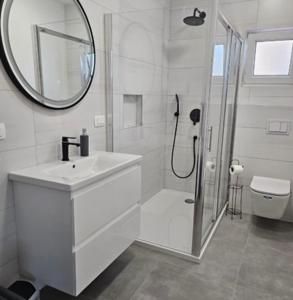 une salle de bain blanche avec lavabo et douche dans l'établissement Apartman Jim, à Vir 38 autres photos