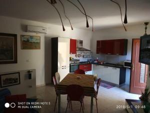 a kitchen with a table and a kitchen with a refrigerator at Alma House - Affitti Brevi Italia in Porto Torres +34 photos