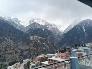 a view of a mountain range with snow covered mountains at Hotel Cafeteria Roof in Kalpa +26 photos
