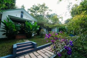 a garden with purple flowers and a house at Le Vista Resort in Sultan Bathery