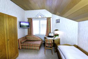a bedroom with a bed and a chair and a window at Gasthaus Seehof in Iznang