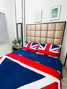 a bed with red white and blue blankets and pillows at The Pine Lodge- Bukit Tinggi Klang in Klang