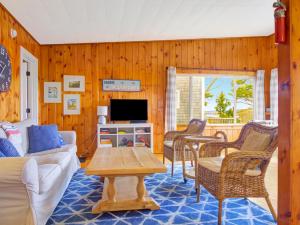 un soggiorno con un divano e una TV di Spinneys Guesthouse & Beach Cottages a Phippsburg