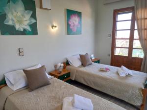 a hotel room with two beds and a window at Amazing Swimming Pool Stamatia-Maria Apt in Kavros