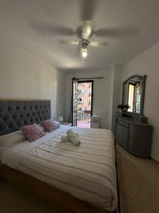 a bedroom with a large bed and a ceiling fan at Port Saplaya 3 Valencia in Port Saplaya