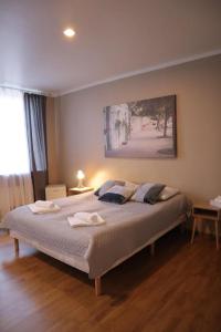 a bedroom with a bed with two towels on it at Viesnīca Kandava in Kandava +25 photos