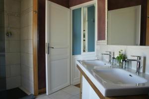 łazienka z dwiema umywalkami i prysznicem w obiekcie Le Clos Saint-Gilles w mieście Ardevon