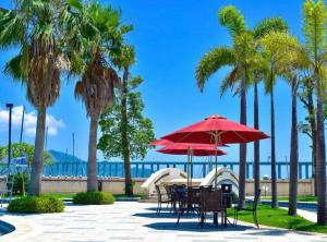 惠州Huizhou Hazens East Bay Resort的一个带桌椅的庭院,棕榈树