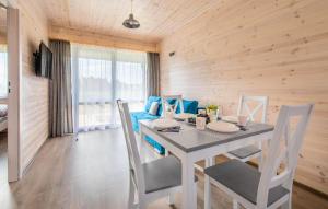 ein Esszimmer mit einem weißen Tisch und Stühlen in der Unterkunft Gorgeous Home In Krynica Morska in Krynica Morska