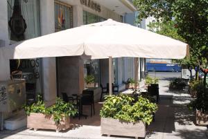 a white umbrella sitting on top of a patio at Glaros Hotel in Piraeus