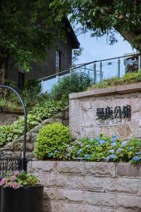 a sign for a building with flowers on a wall at CHONGQING MANQUE MANSION in Chongqing