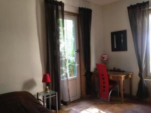a bedroom with a bed and a desk and a window at La Mandarinette in La Seyne-sur-Mer