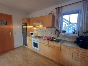 ウッテンドルフにあるApartment Renn in Uttendorfの木製のキャビネットとシンクと窓のあるキッチン