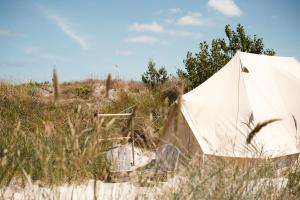 a tent in the sand in a field at Dunes Beach Camp in Neksø +10 photos