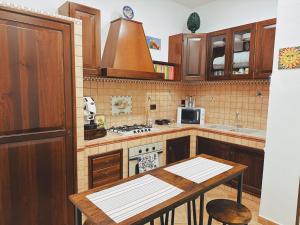 a kitchen with a table and a stove top oven at Sicania - In centro Storico a Palermo in Palermo