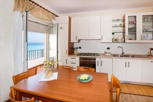 a kitchen and dining room with a table and a window at Appartamento Letojanni-Taormina in Letojanni