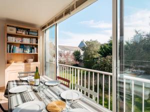 una sala da pranzo con un tavolo e una grande finestra di La Trinité-sur-Mer : Appartement 3 pièces avec parking, proche port et plages - FR-1-477-180 a La Trinité-sur-Mer
