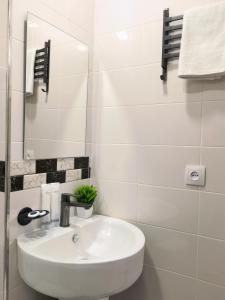a white bathroom with a sink and a mirror at Hayq Hotel in Yerevan