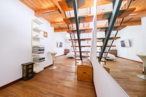 a spiral staircase in a loft with wooden ceilings at Via Fiorenza Apartment in Livorno